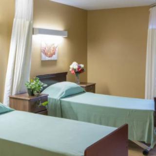 A hospital room with two neatly made beds and calming decor.