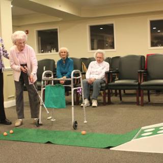 Seniors enjoying a fun indoor golfing activity, promoting social interaction and recreation.