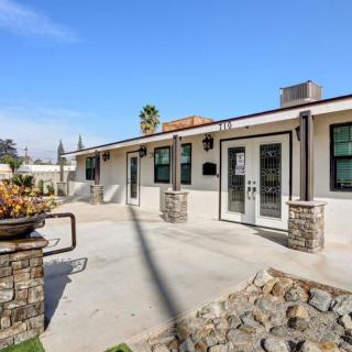 A modern single-story house exterior with a spacious patio and large windows.