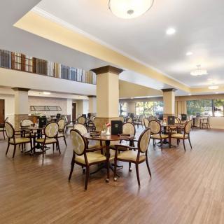 A spacious dining area with elegant tables and chairs, featuring bright interior lighting.