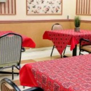 A cozy restaurant interior featuring red tablecloths on neatly arranged tables.
