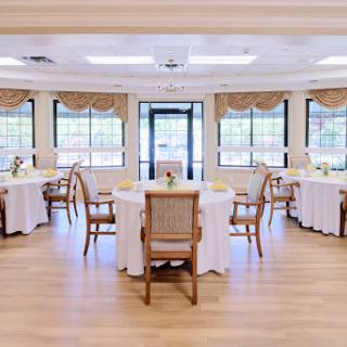 A beautifully arranged dining area featuring elegant tables and chairs, bathed in natural light.