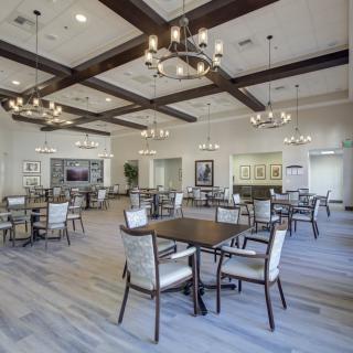 A modern dining room with elegant chandeliers and wooden beam decorations.