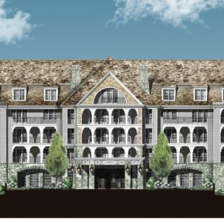 A traditional multi-story hotel building surrounded by trees under a clear blue sky.