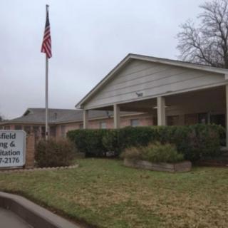 A nursing home with an American flag and a sign in front of the entrance.