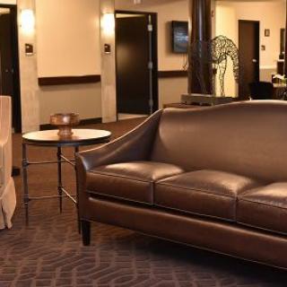 A modern lobby with a leather sofa and a small round table.