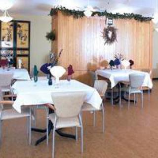 A well-decorated dining area with neatly arranged tables and chairs, featuring elegant table settings.