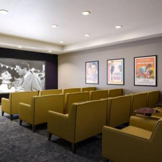 A cozy home theater room with comfortable seating and classic movie posters on the wall.