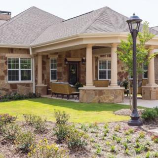 A charming residential house with a well-maintained front yard and a welcoming porch.