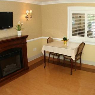 Cozy living room with a fireplace, small table, and wall-mounted TV.