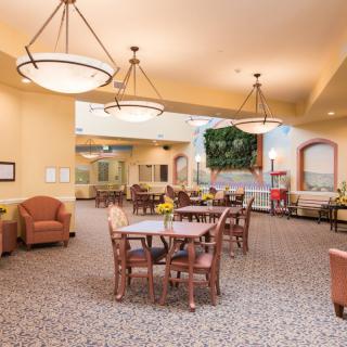 A spacious and well-lit dining area with wooden furniture and comfortable seating.