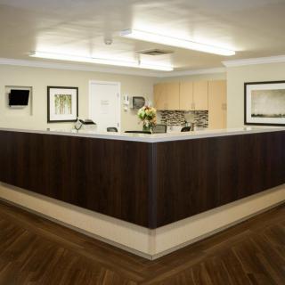 A modern reception area with a minimalist design and dark wood desk.