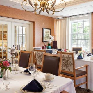 An elegant dining room with neatly set tables and a chandelier.