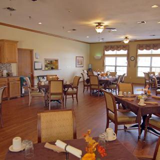 An empty dining room with neatly arranged tables and chairs.