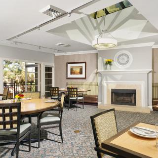 A modern dining room with elegant furniture, a fireplace, and tasteful artwork on the wall.