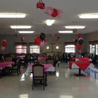 A decorated event hall with balloons and tables set for a party.