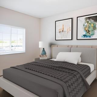 A modern bedroom with a neatly made bed and stylish decor.