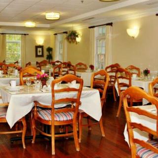 A well-arranged dining room with neatly set tables and chairs.