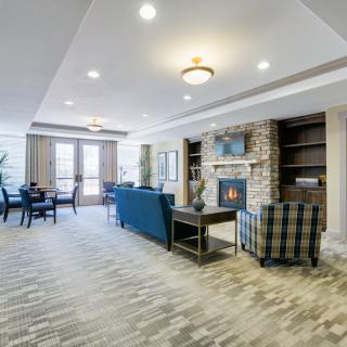 A modern and cozy living room featuring a fireplace, blue sofas, and stylish decor.