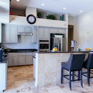 Modern kitchen interior with bar stools and sleek appliances.