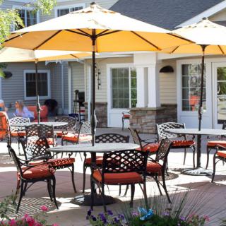 A sunny outdoor patio with tables, chairs, and umbrellas, ideal for relaxation.