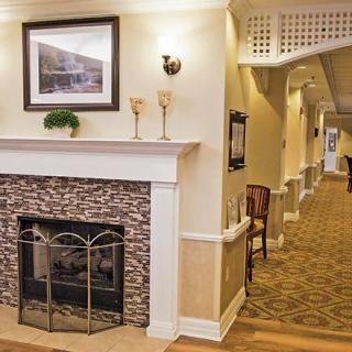 A cozy interior with a fireplace and a warmly lit hallway.