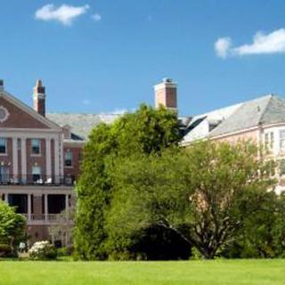 A large building on a campus surrounded by greenery and open space.