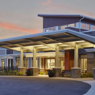 Modern building exterior with illuminated entrance during evening.