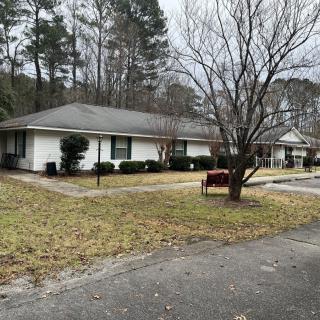 A suburban house with a driveway and surrounding lawn.