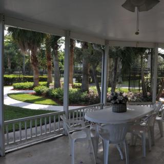 A patio with a white table and chairs overlooking a beautifully landscaped garden.