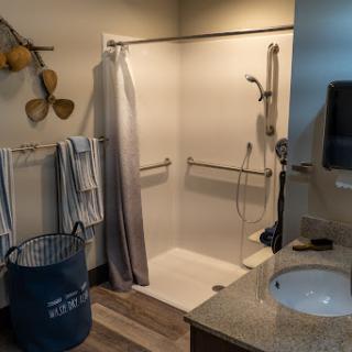 A modern bathroom featuring a shower space, towels neatly hung, and a stylish sink area.