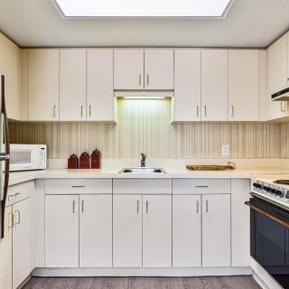 A modern kitchen interior with white cabinets and appliances.