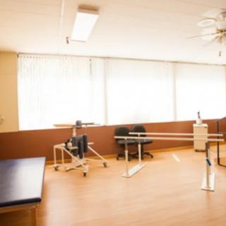 A bright rehabilitation room equipped with physical therapy tools and exercise machines.