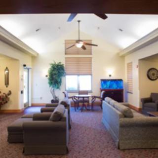 A cozy living room with comfortable seating and a ceiling fan.