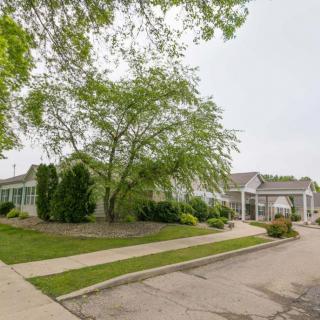 A quiet suburban street lined with houses and lush greenery.