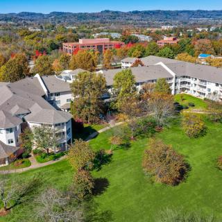 Aerial view of a large residential building surrounded by lush greenery and trees.