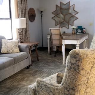A cozy living room with elegant furniture and a desk setup.