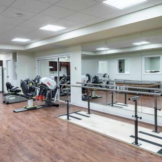 A fitness studio with exercise equipment and mirrored walls.