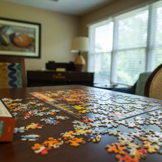 A cozy living room with a puzzle partially assembled on the table.