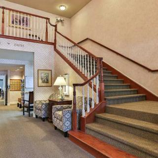 A traditional hallway with a staircase and seating area.
