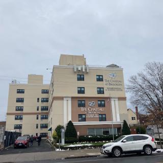 A modern healthcare facility with a welcoming entrance and cloudy sky.