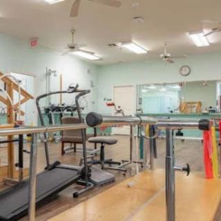 A well-equipped rehabilitation gym featuring various exercise machines and rehabilitation tools.
