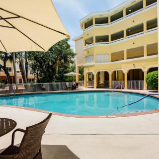 A sunny day at a hotel with an inviting swimming pool and patio seating.