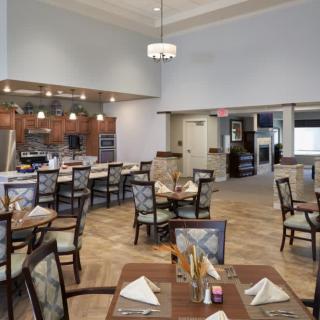 A spacious dining room with elegantly set tables and comfortable seating.