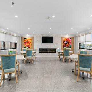 A modern dining area featuring light-colored walls, stylish furniture, and vibrant artwork.