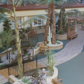 A serene indoor space featuring palm trees, a winding walkway, and benches for relaxation.