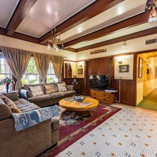 A cozy living room with traditional decor, featuring wood beams, a comfortable sofa, and a classic rug.