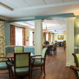 A well-lit dining area with wooden floors and elegant furniture.