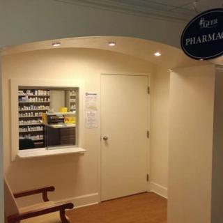 A small pharmacy counter inside a building with shelves of medicine visible in the background.