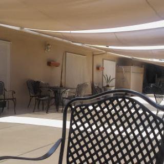 A quiet outdoor seating area under a sunshade.
